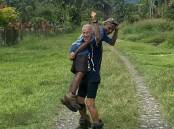 Geoff Zipper carried his porter Kaven under the Kokoda Trail arch. Picture supplied