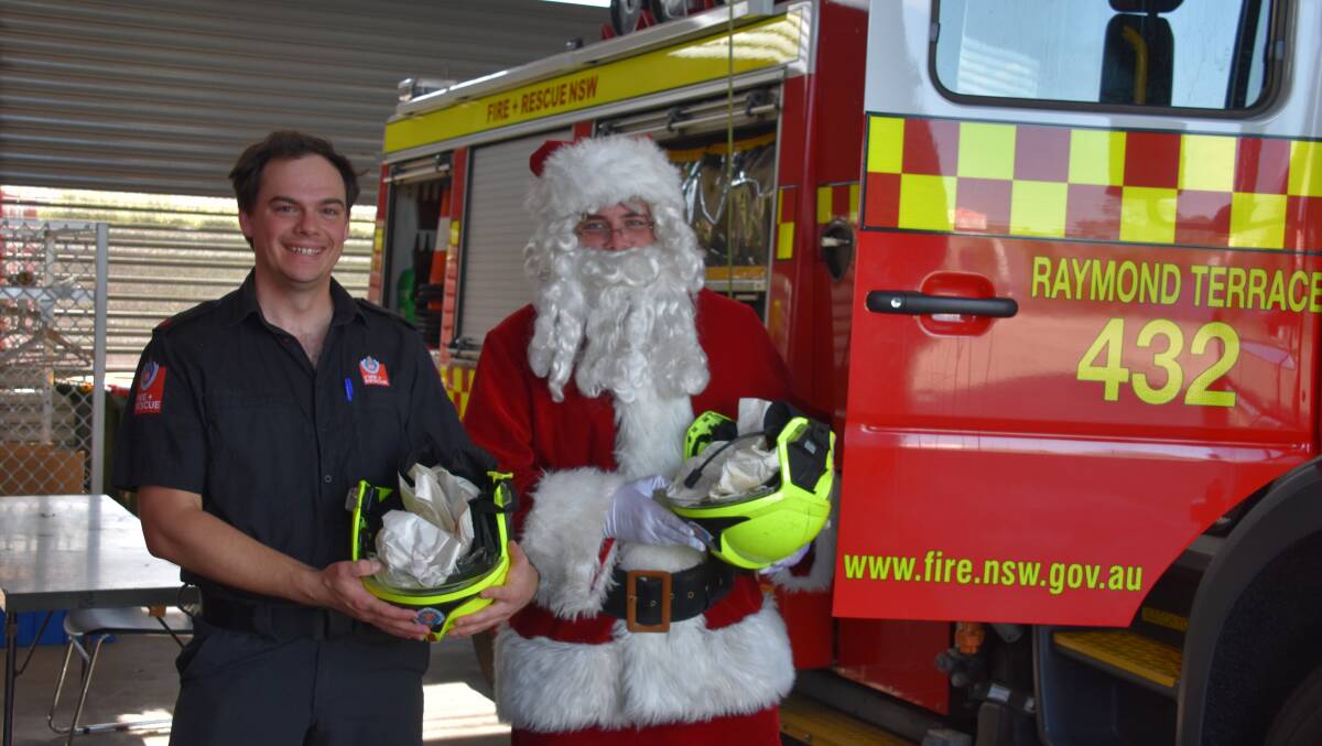 Raymond Terrace Fire and Rescue deputy captain Giacomo Arnott and Santa are ready to hit the streets for Santa's annual lolly run. Picture by Laura Rumbel