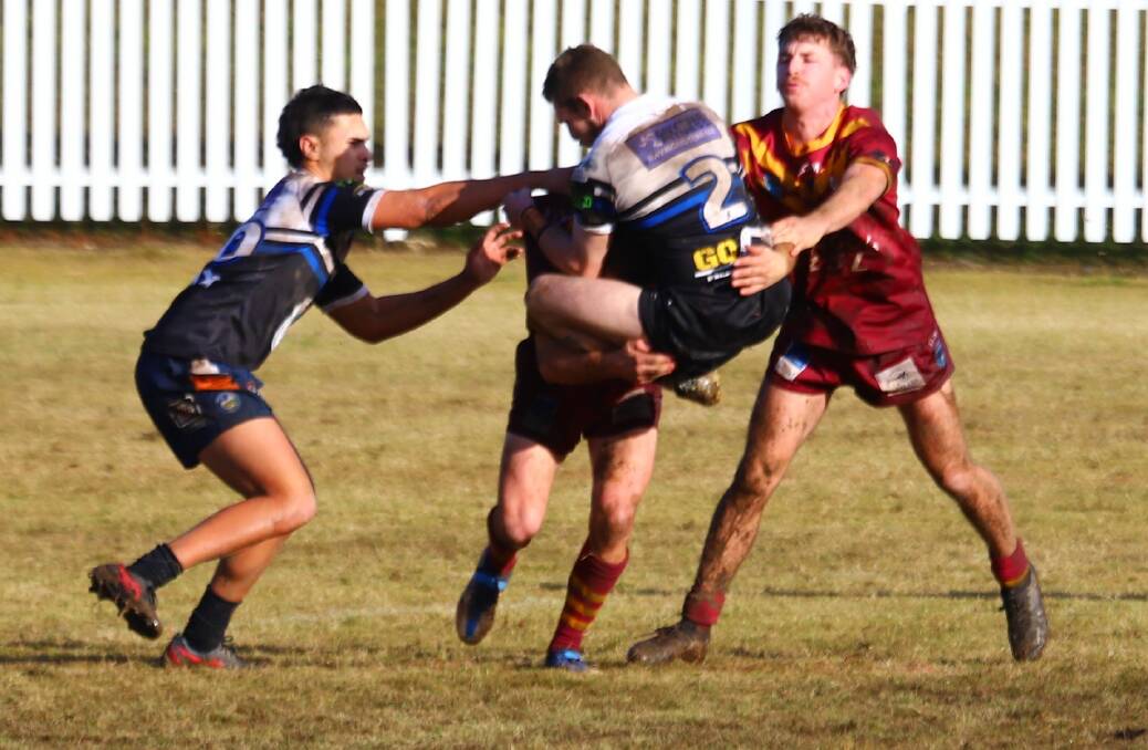 The Raymond Terrace wing holds on as a Dungog Warriors players charges forward in C-grade on Sunday. Picture by Lauren Johns